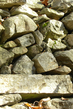 Zu einer Mauer geschichtete Steine unterschiedlicher Größe